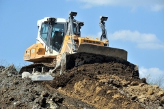 A bulldozer pushes earth on an embankment