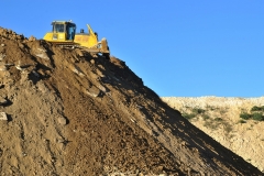 A bulldozer pushes earth in the discharging zone